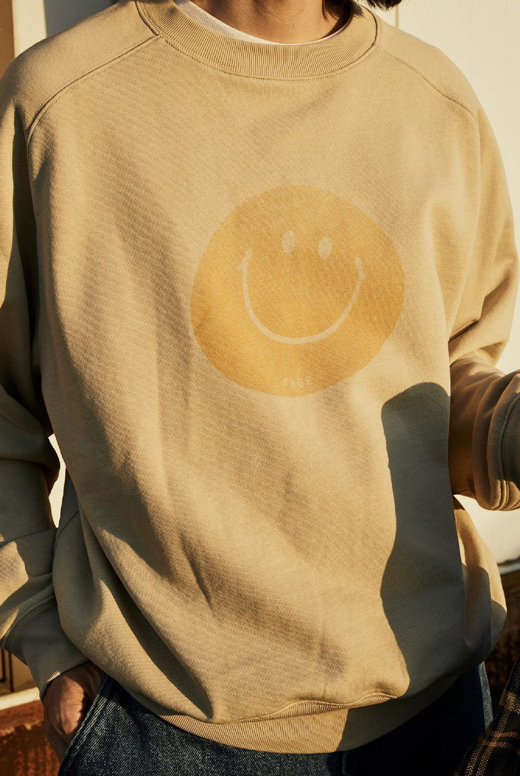 USAGE Washed Cotton Raglan Smiley Sweatshirt in Beige - On Male Model