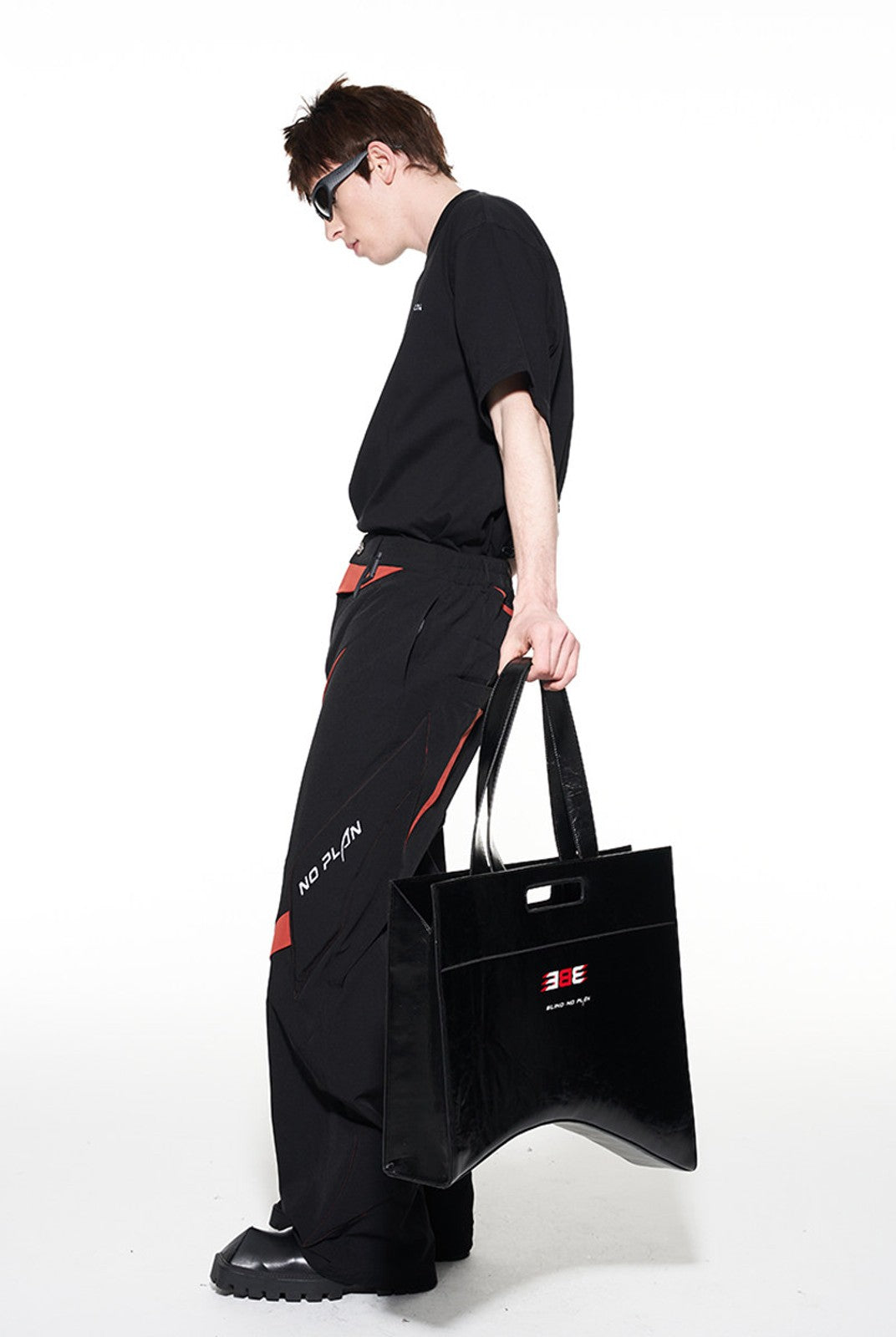 BLINDNOPLAN Textured Faux Leather Asymmetric Tote in Black - On Male Model