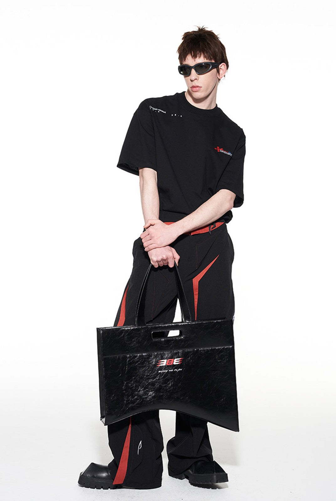 BLINDNOPLAN Textured Faux Leather Asymmetric Tote in Black - On Male Model