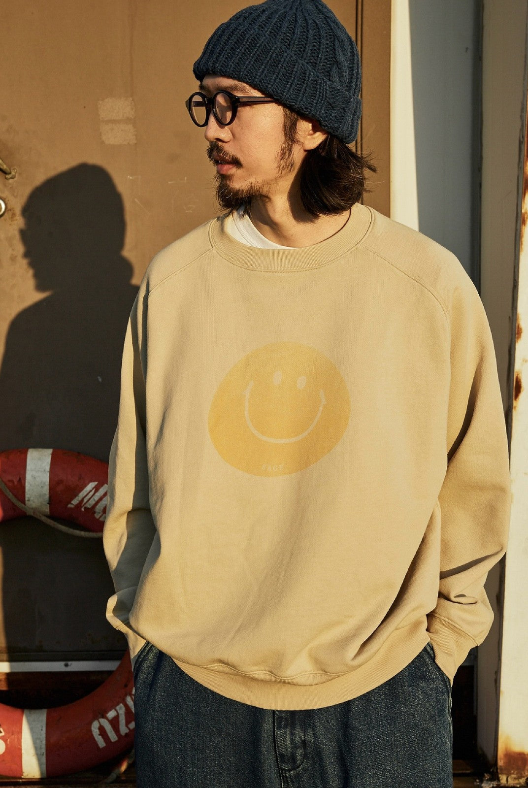 USAGE Washed Cotton Raglan Smiley Sweatshirt in Beige - On Male Model