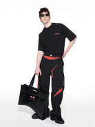 BLINDNOPLAN Textured Faux Leather Asymmetric Tote in Black - On Male Model