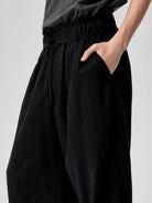 SIMPLE PROJECT Lyocell Blend Curved Leg Trousers in Black - On Model
