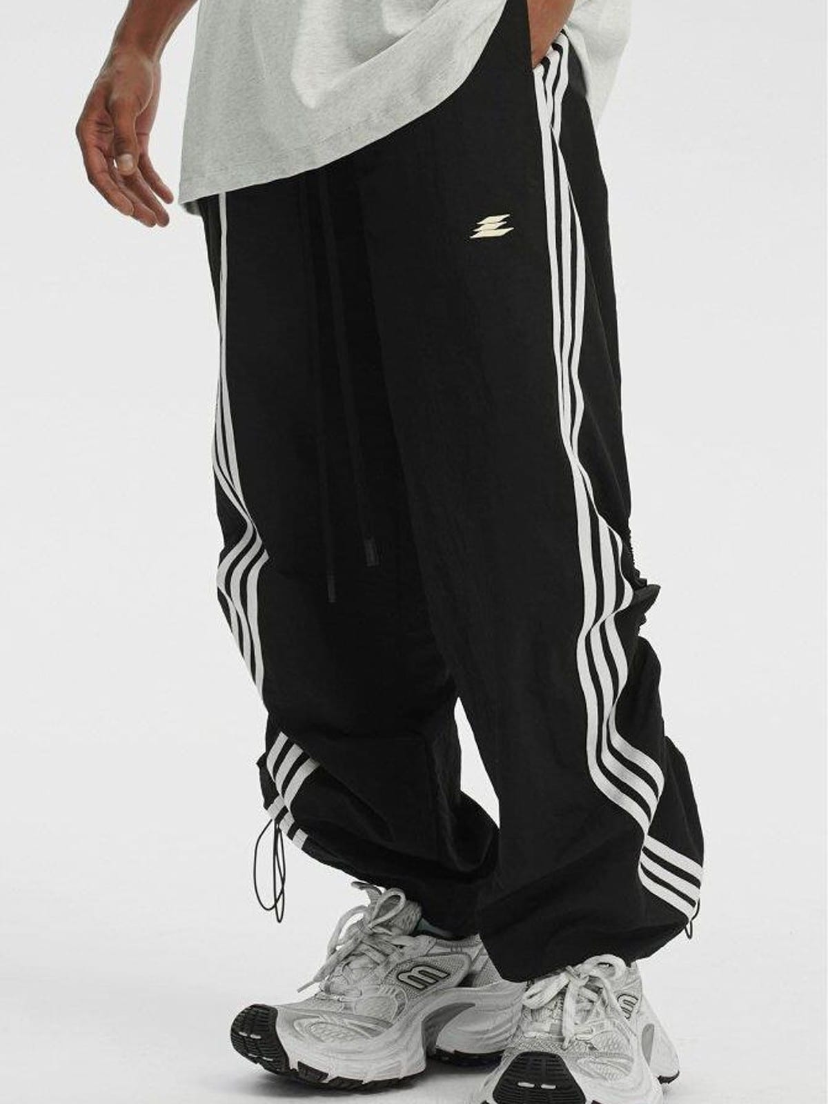 LOSTCTRL Ruched Asymmetrical Striped Track Pants in Black - On Male Model