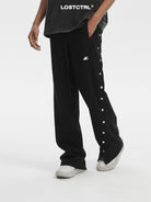 LOSTCTRL Asymmetrical Snap Button Cotton Pants in Black - On Male Model