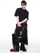 BLINDNOPLAN Textured Faux Leather Asymmetric Tote in Black - On Male Model