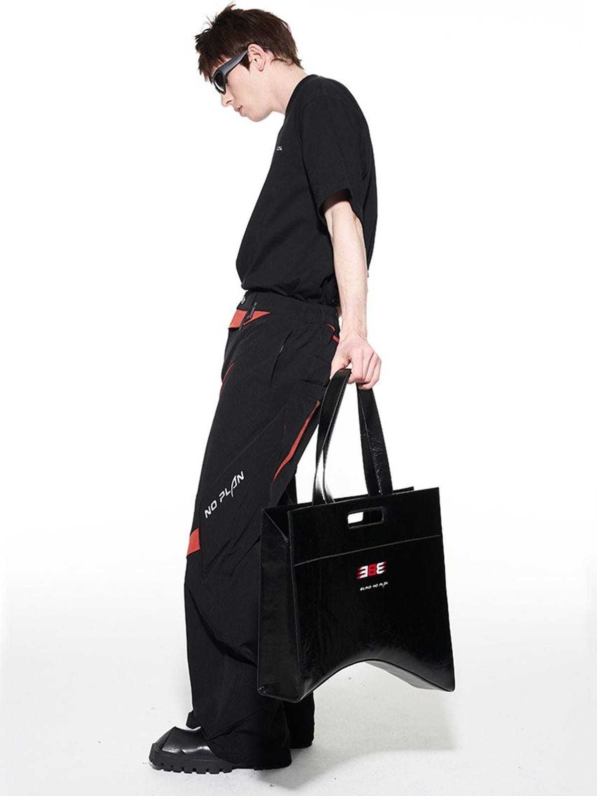 BLINDNOPLAN Textured Faux Leather Asymmetric Tote in Black - On Male Model