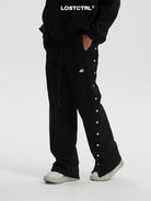 LOSTCTRL Asymmetrical Snap Button Cotton Pants in Black - On Model