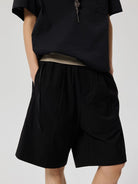 SIMPLE PROJECT Logo Tape Wool Blend Shorts in Black - On Model