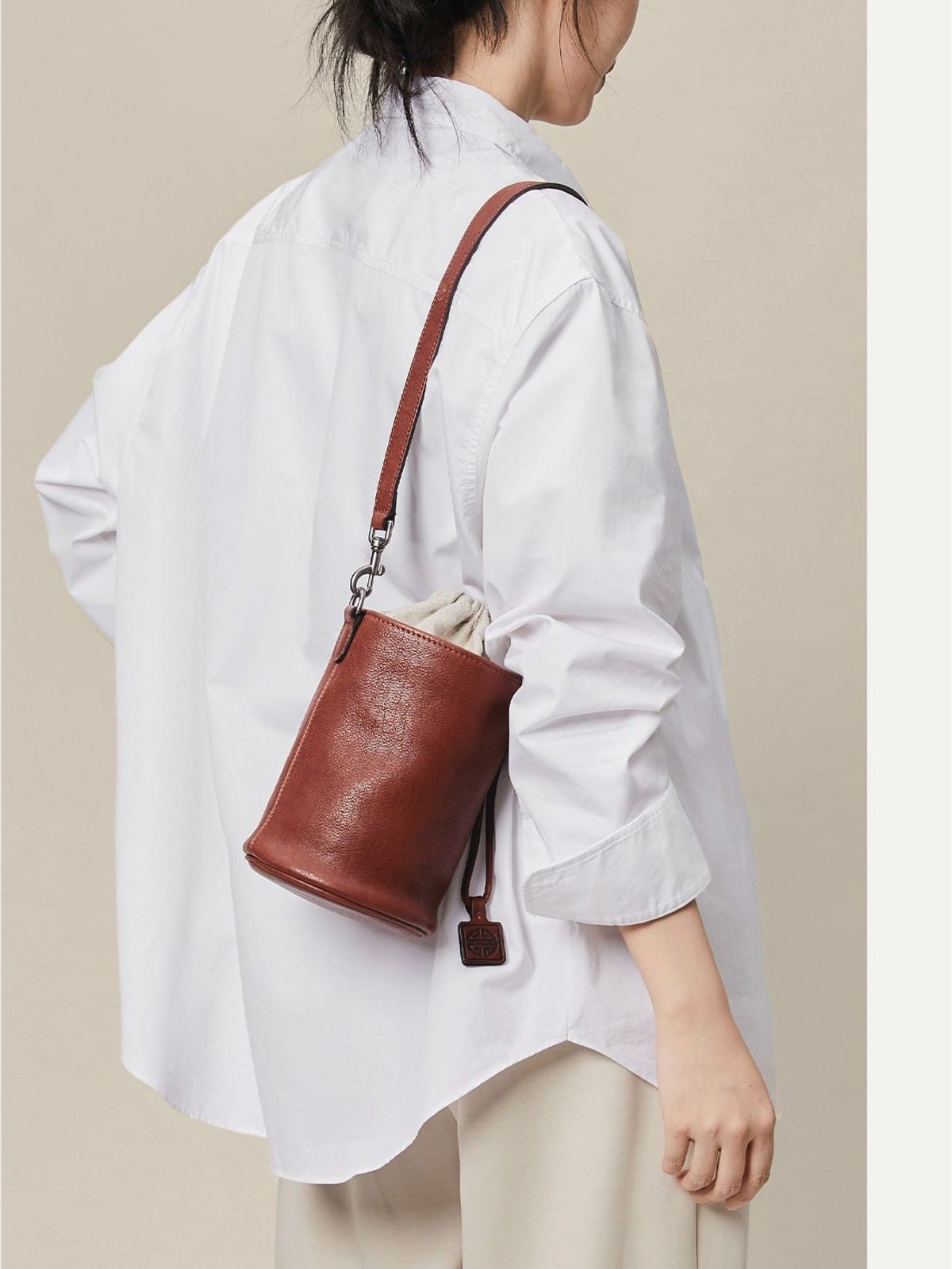 QIUZHEN Leather Drawstring Bucket Bag in Dark Brown - On Female Model