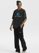 LOSTCTRL Asymmetrical Snap Button Cotton Pants in Black - On Male Model