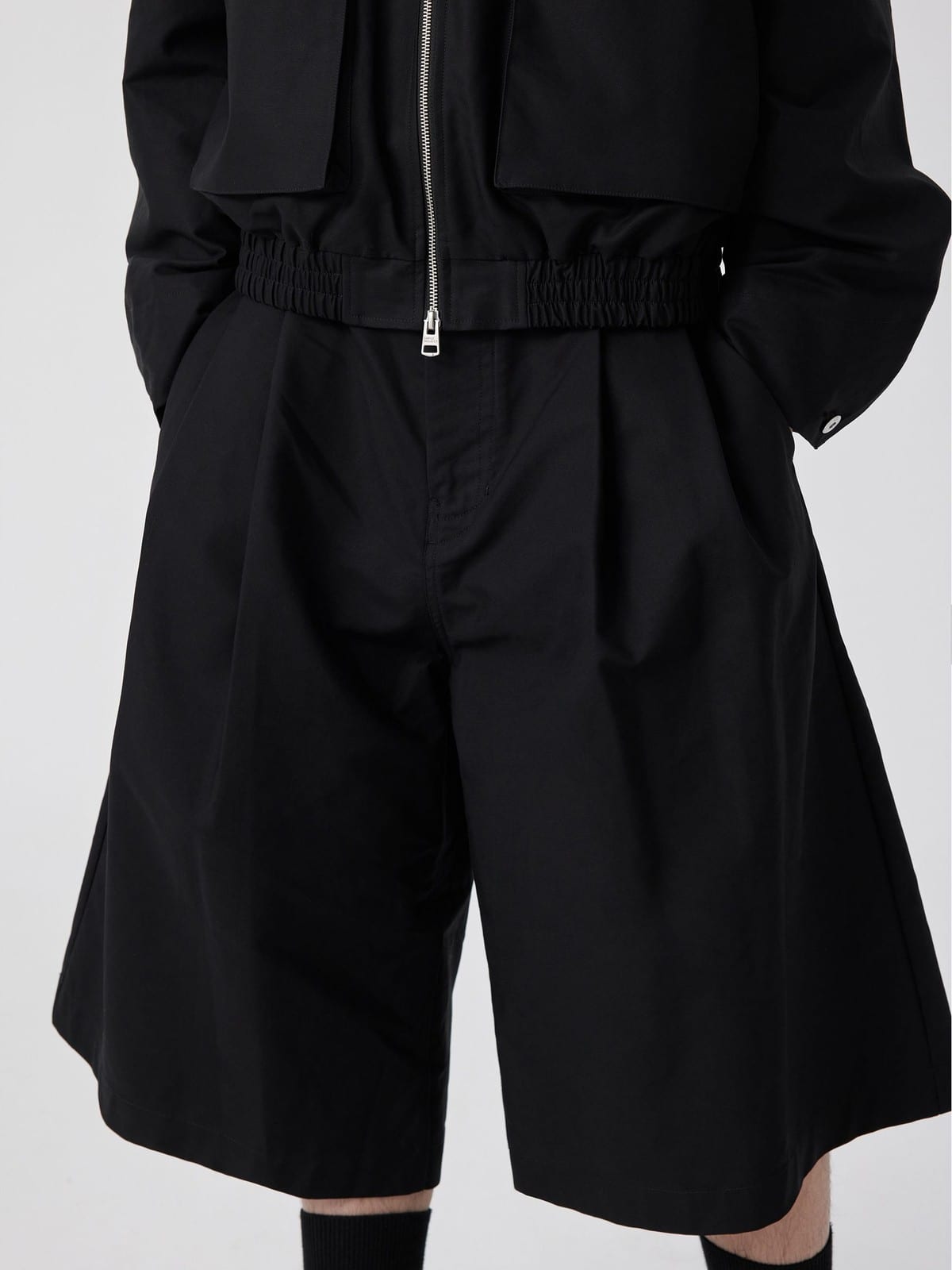 SIMPLE PROJECT Cotton Pleated Cropped Shorts in Black - On Model