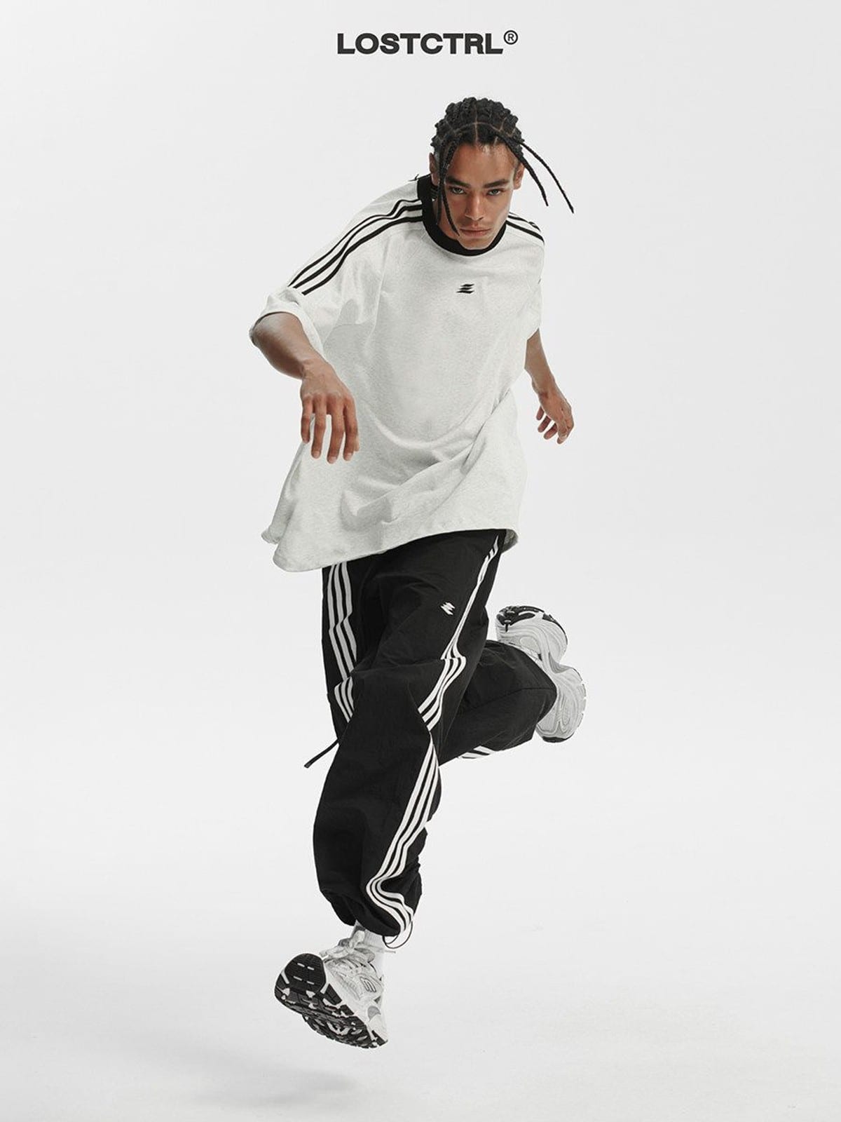 LOSTCTRL Ruched Asymmetrical Striped Track Pants in Black - On Male Model