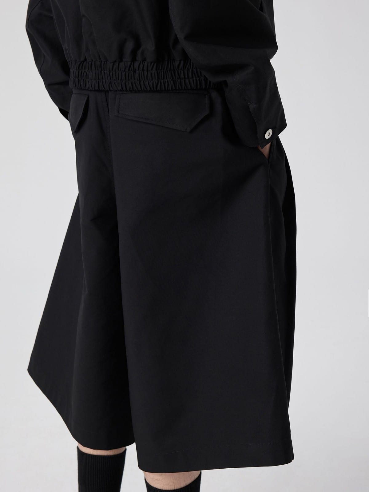 SIMPLE PROJECT Cotton Pleated Cropped Shorts in Black - On Model
