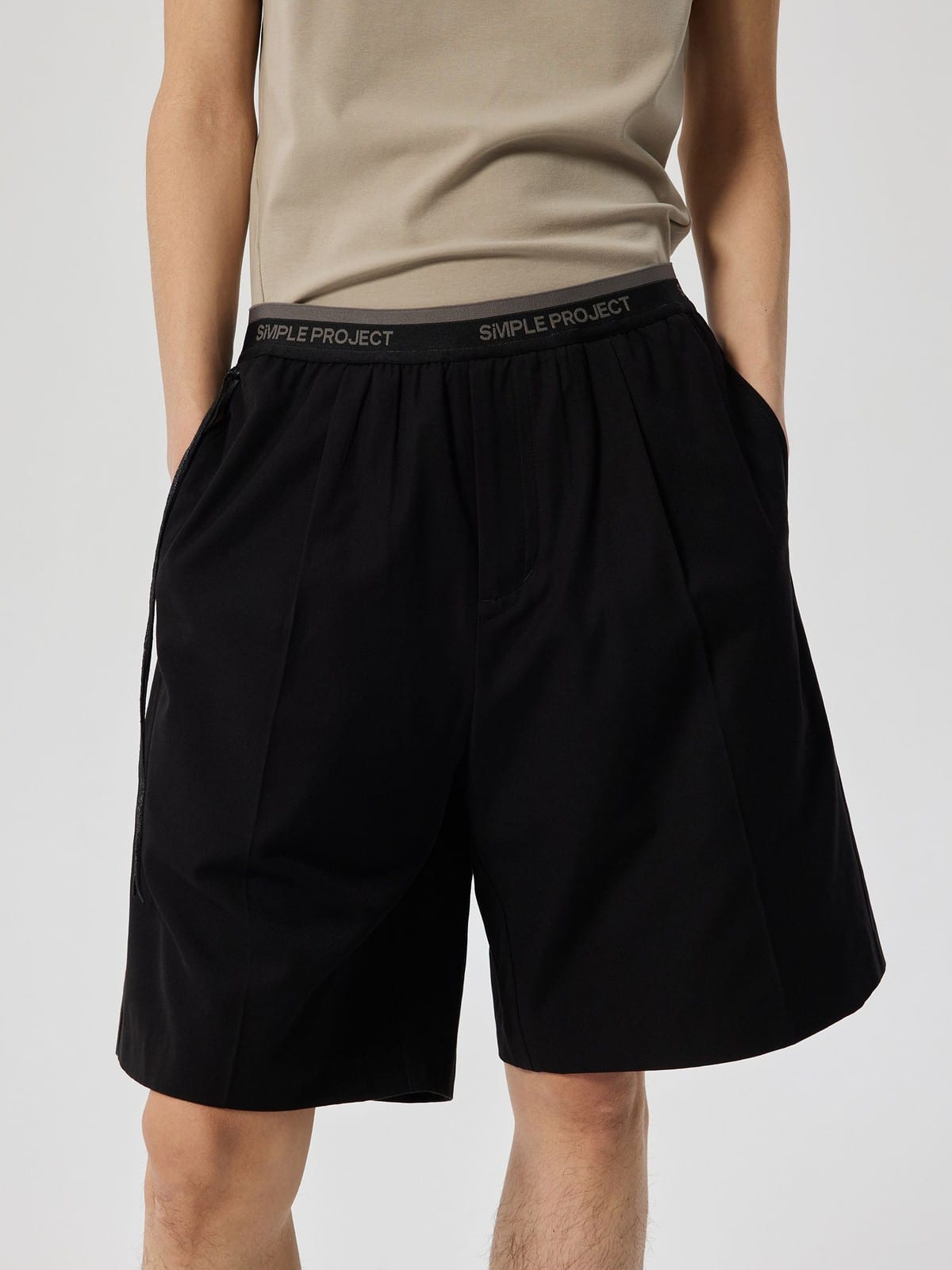 SIMPLE PROJECT Logo Tape Wool Blend Shorts in Black - On Male Model