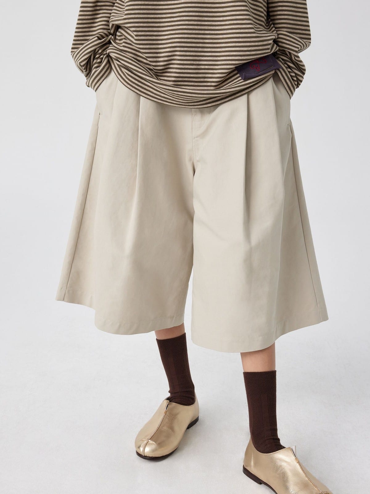 SIMPLE PROJECT Cotton Pleated Cropped Shorts in Beige - On Model